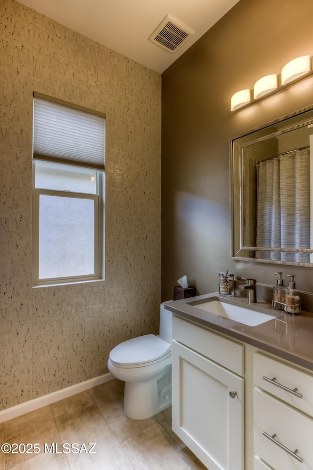 bathroom featuring visible vents, baseboards, toilet, tile patterned floors, and vanity