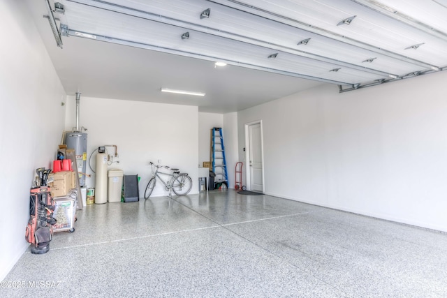 garage featuring baseboards and water heater