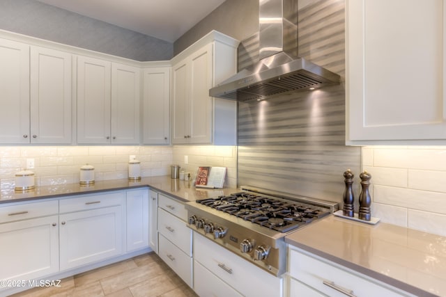 kitchen with white cabinetry, decorative backsplash, wall chimney exhaust hood, and stainless steel gas cooktop