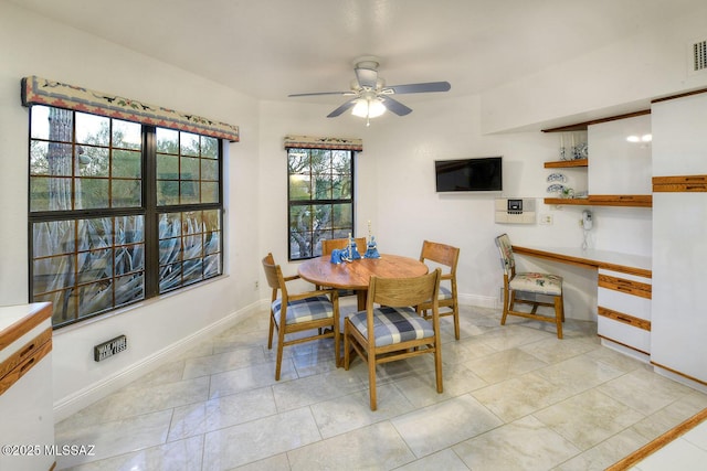 dining area featuring built in desk, light tile patterned floors, baseboards, and a ceiling fan