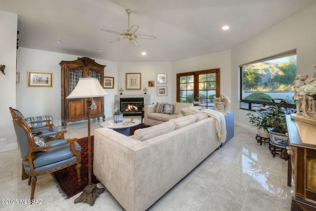 living room with baseboards, a tiled fireplace, marble finish floor, french doors, and recessed lighting