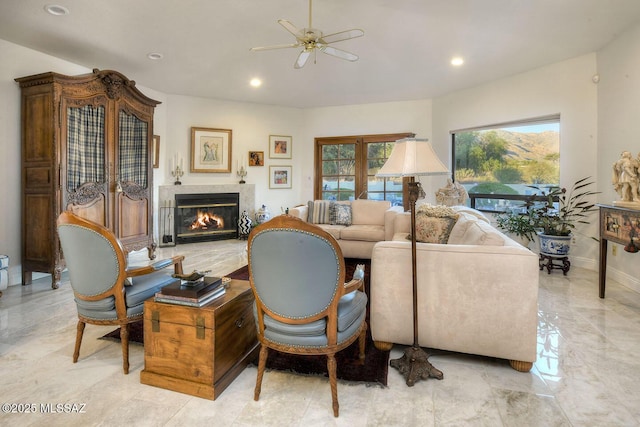 living area with marble finish floor, baseboards, a wealth of natural light, and a glass covered fireplace