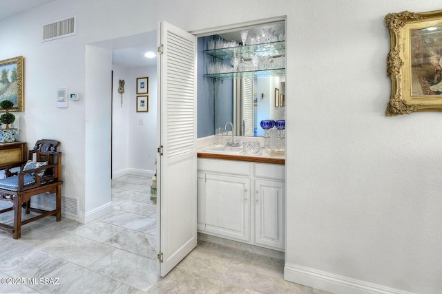 bathroom featuring visible vents, vanity, and baseboards