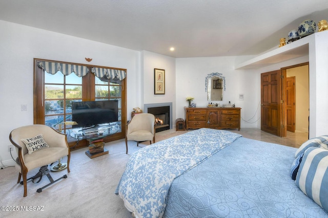 bedroom featuring a lit fireplace, recessed lighting, and light colored carpet