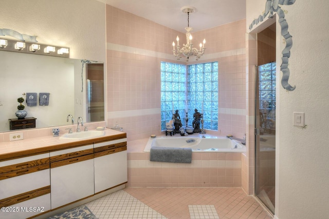 bathroom featuring a stall shower, a garden tub, tile patterned flooring, vanity, and a notable chandelier