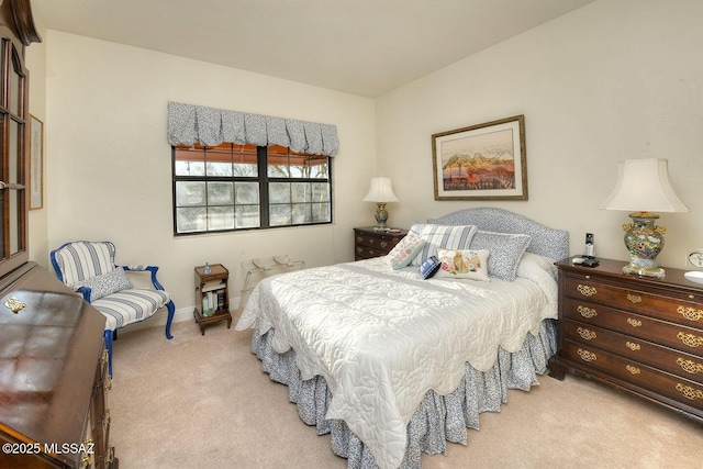 bedroom featuring light carpet and baseboards