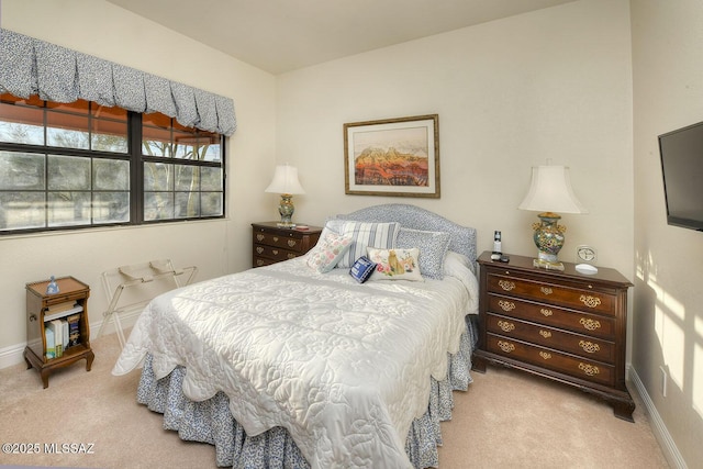 bedroom with light carpet and baseboards