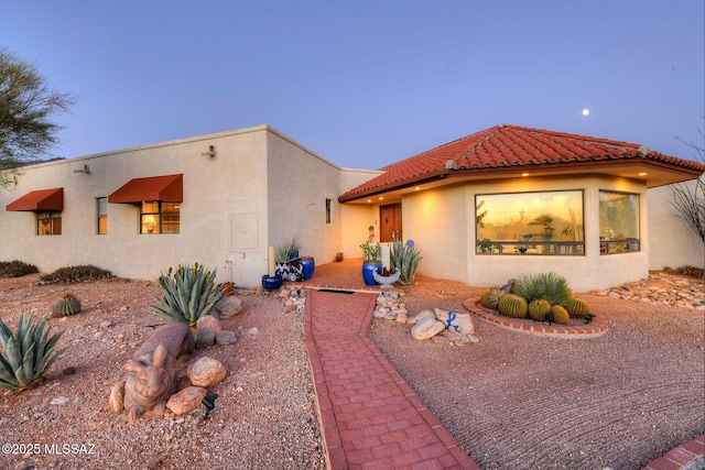 view of front of home featuring a tile roof and stucco siding