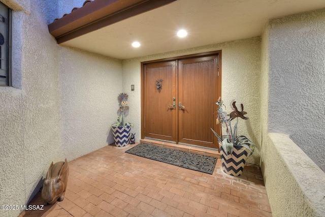 doorway to property featuring stucco siding