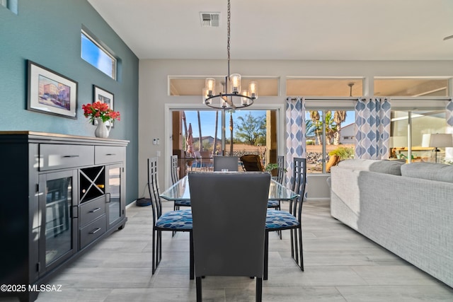 dining space with a chandelier, visible vents, light wood-style floors, and baseboards