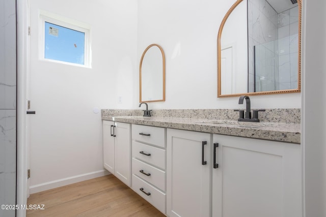 15809 N Twin Lakes Dr NW, Tucson, AZ 85739 - bathroom with double vanity, a sink, a stall shower, and wood finished floors