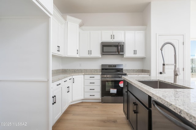 15809 N Twin Lakes Dr NW, Tucson, AZ 85739 - kitchen with white cabinetry, a sink, appliances with stainless steel finishes, and light wood finished floors