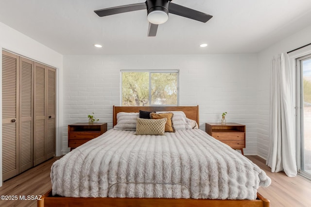 bedroom with access to exterior, light wood finished floors, a closet, and recessed lighting