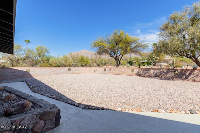 view of yard featuring a fenced backyard and a mountain view