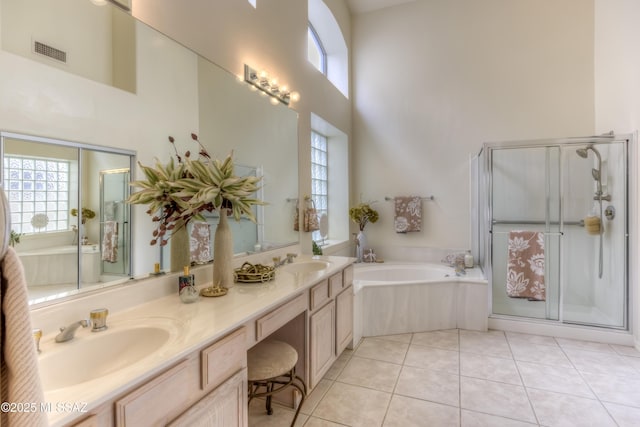 bathroom with tile patterned flooring, a garden tub, a towering ceiling, and a sink