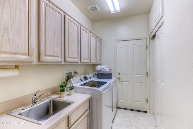 clothes washing area featuring visible vents, light tile patterned flooring, cabinet space, a sink, and washer and dryer