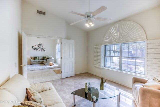 living room featuring visible vents, high vaulted ceiling, a ceiling fan, light tile patterned floors, and baseboards