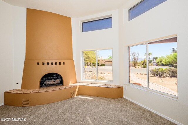 unfurnished living room with carpet floors, visible vents, and baseboards