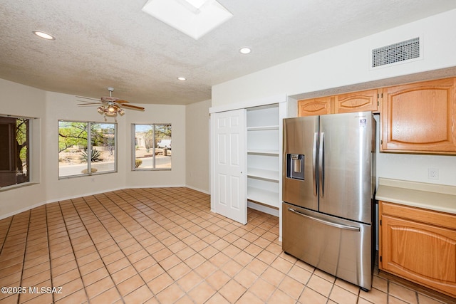 kitchen featuring recessed lighting, stainless steel refrigerator with ice dispenser, visible vents, and light countertops