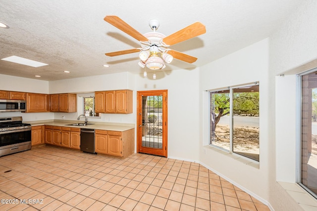 kitchen featuring recessed lighting, stainless steel appliances, light countertops, light tile patterned floors, and a sink