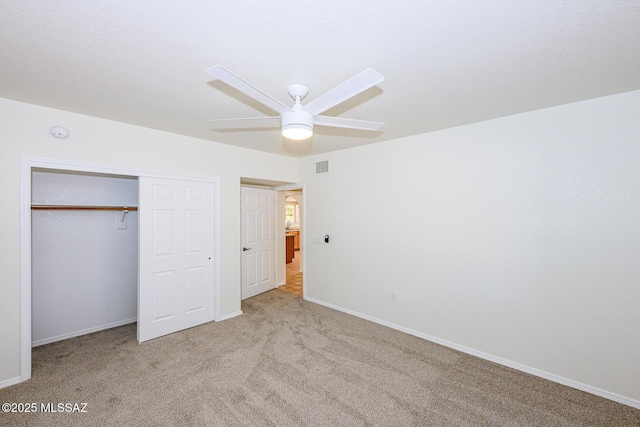 unfurnished bedroom featuring visible vents, a closet, baseboards, carpet flooring, and ceiling fan