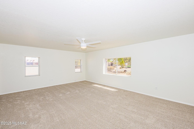 spare room featuring baseboards, carpet floors, and ceiling fan