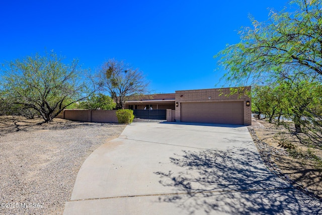 single story home featuring concrete driveway, brick siding, fence, and a garage