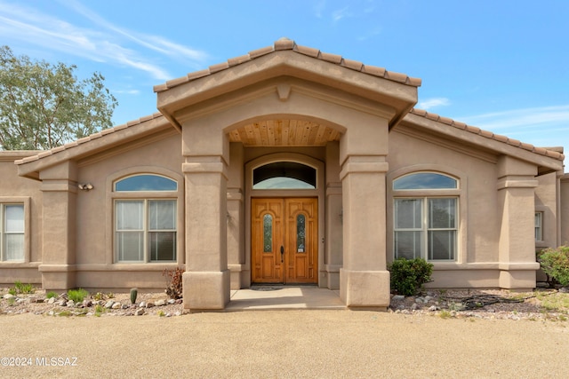 view of exterior entry featuring stucco siding