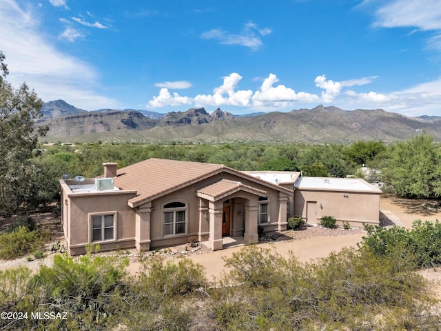 view of front of home featuring a tile roof, a mountain view, and stucco siding