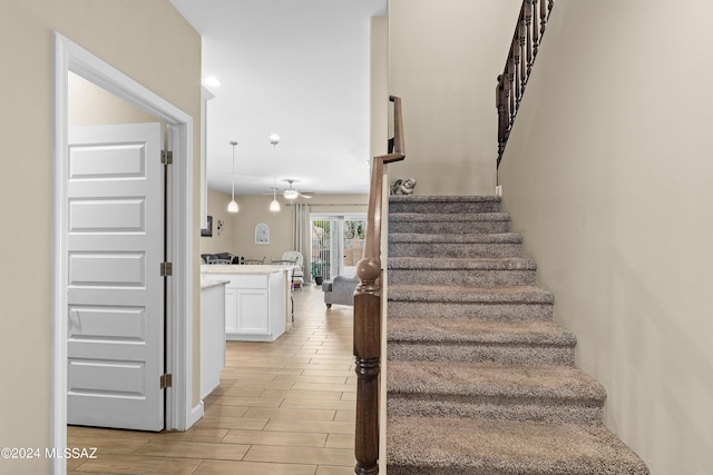 stairway with wood tiled floor and ceiling fan