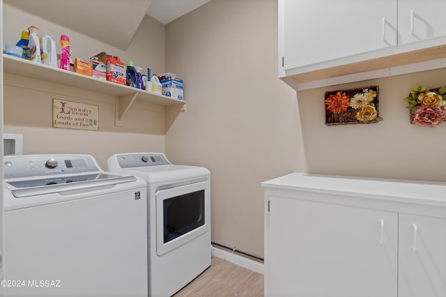 laundry room with light wood-type flooring, cabinet space, and washing machine and clothes dryer