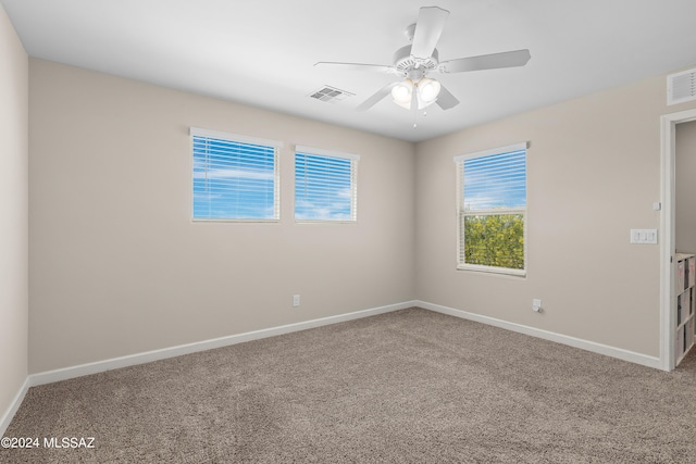 empty room with ceiling fan, carpet, visible vents, and baseboards