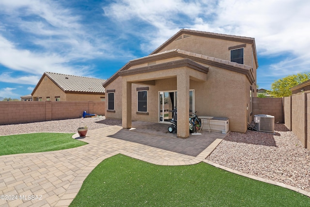 back of house with central air condition unit, a patio area, a fenced backyard, and stucco siding