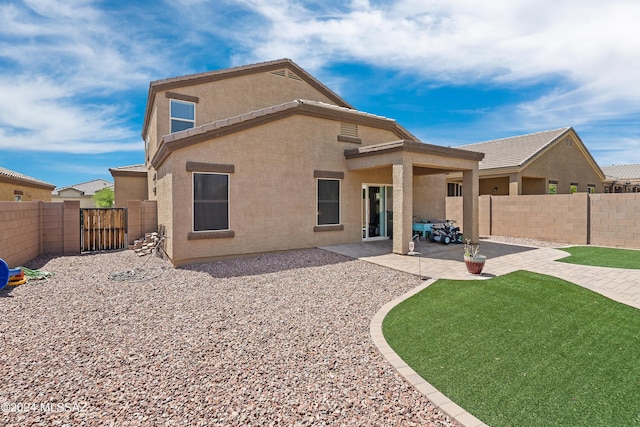 rear view of property featuring a patio area, a fenced backyard, and stucco siding