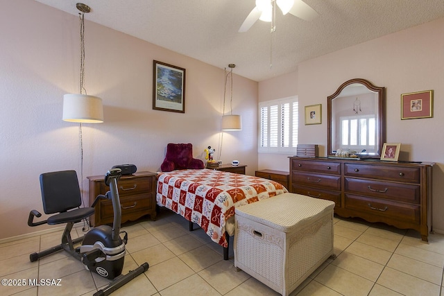 bedroom with a textured ceiling, light tile patterned flooring, and a ceiling fan