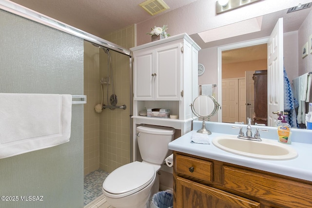 bathroom featuring toilet, a stall shower, visible vents, and vanity