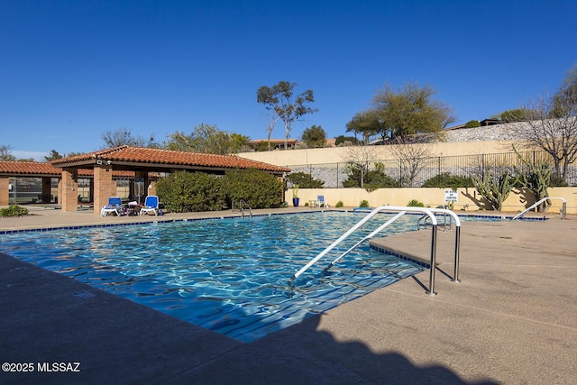 pool featuring fence and a patio