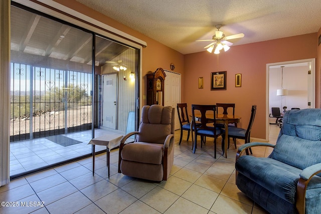 living area featuring ceiling fan, a textured ceiling, and light tile patterned floors