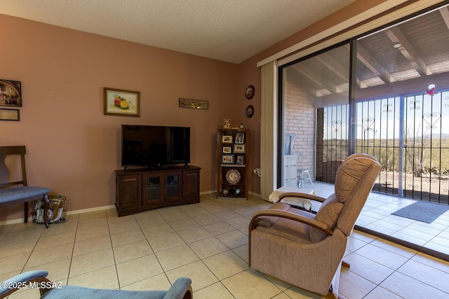 living room with a textured ceiling, baseboards, and light tile patterned floors