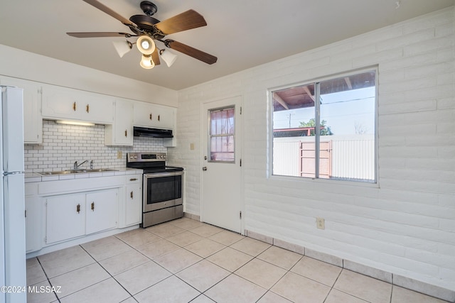 kitchen with light tile patterned floors, white cabinets, a sink, stainless steel range with electric stovetop, and under cabinet range hood