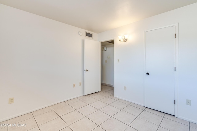 unfurnished bedroom featuring light tile patterned floors, visible vents, and baseboards