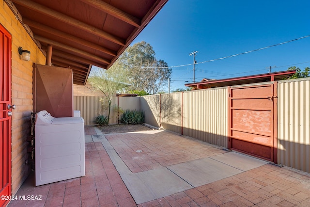 view of patio featuring a fenced backyard, a gate, and washer / clothes dryer