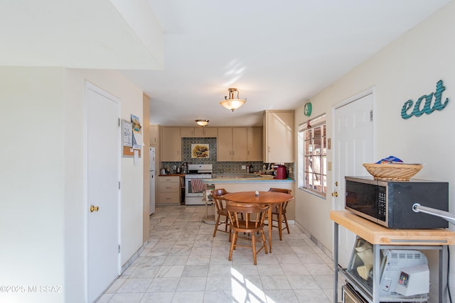 kitchen featuring marble finish floor, stainless steel appliances, light countertops, decorative backsplash, and a peninsula