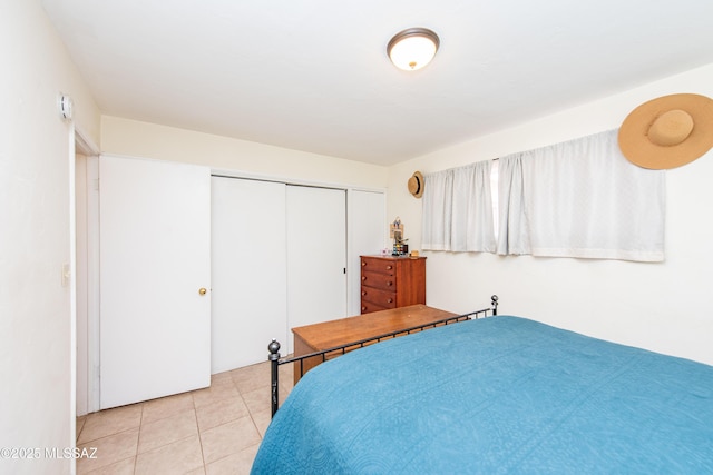 bedroom with a closet and light tile patterned floors