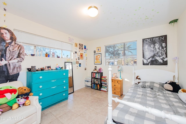 bedroom with light tile patterned floors and multiple windows