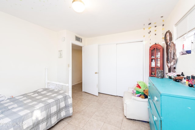 bedroom with a closet, visible vents, and light tile patterned flooring