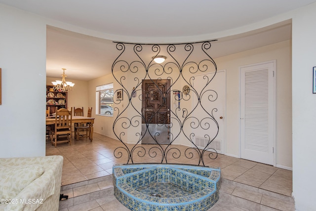 tiled living area featuring visible vents and a notable chandelier