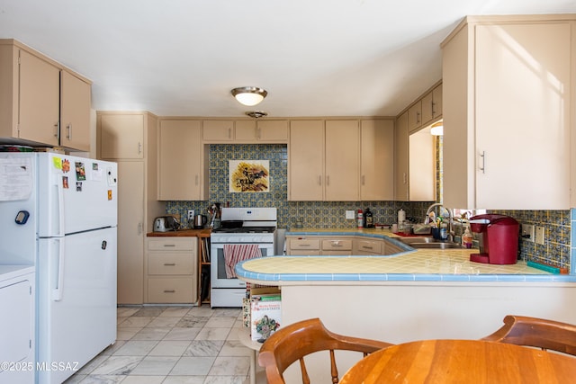 kitchen featuring marble finish floor, white appliances, a sink, and cream cabinetry