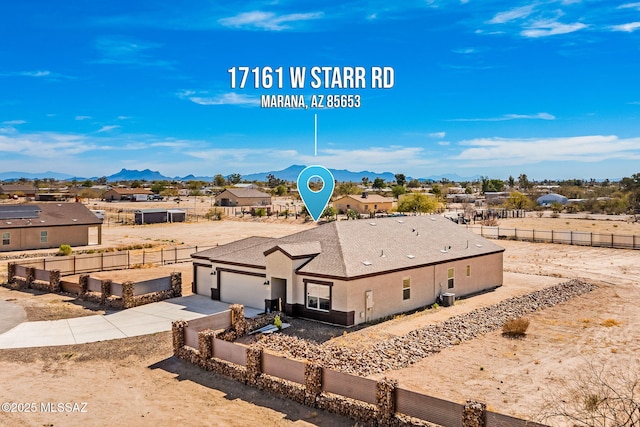 view of front of house featuring a garage, concrete driveway, a mountain view, and fence