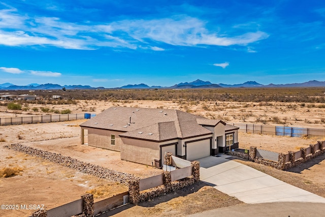 exterior space featuring a garage, concrete driveway, and a mountain view